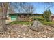 Ranch home featuring a well-kept lawn, rock garden, attached garage, and a front porch at 13621 E Center Ave, Aurora, CO 80012
