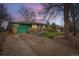 Ranch home at twilight featuring a well-kept lawn, rock garden, attached garage, and a ramp at 13621 E Center Ave, Aurora, CO 80012