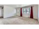 Bright living room with large bay window and red curtains, creating a warm and welcoming atmosphere at 13621 E Center Ave, Aurora, CO 80012
