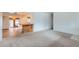 Open living room featuring a bar area and carpet flooring, providing an inviting space for entertaining at 13621 E Center Ave, Aurora, CO 80012