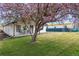 Beautifully landscaped front yard featuring a lush lawn, shade tree, and comfortable porch seating at 20 S Harlan St, Lakewood, CO 80226