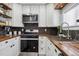 Modern kitchen boasts wood counters, white cabinets, stainless steel appliances, and black backsplash at 20 S Harlan St, Lakewood, CO 80226