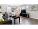 Comfortable living room featuring hardwood floors, a sofa, and a large TV for entertainment at 20 S Harlan St, Lakewood, CO 80226
