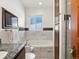 Elegant bathroom featuring marble tiling, a soaking tub, granite counters, and a convenient built-in TV at 2535 Leyden St, Denver, CO 80207