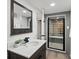 Modern bathroom featuring a glass block shower with mosaic tile flooring and a sleek vanity at 2535 Leyden St, Denver, CO 80207