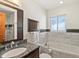 Bathroom featuring granite countertops, marble tile and a tub beneath a large window at 2535 Leyden St, Denver, CO 80207