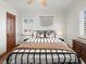 Comfortable bedroom featuring hardwood floors, a ceiling fan, and a queen bed with stylish bedding at 2535 Leyden St, Denver, CO 80207