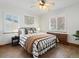 Cozy bedroom featuring hardwood floors, a ceiling fan, and a comfortable queen bed with stylish bedding at 2535 Leyden St, Denver, CO 80207