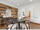 Dining room showcasing a round table, wood accent wall, and arched doorway leading to the hallway at 2535 Leyden St, Denver, CO 80207