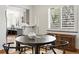 Bright dining room with modern table and chairs, plus natural light from the window with shutters at 2535 Leyden St, Denver, CO 80207