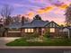 Charming brick home featuring an attached garage and a well-manicured front yard at dusk at 2535 Leyden St, Denver, CO 80207