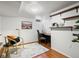 Charming home office featuring hardwood floors, a cozy chair, a desk, and open shelves for storage and decor at 2535 Leyden St, Denver, CO 80207