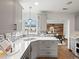 Open kitchen featuring gray cabinets, mosaic backsplash, stainless steel appliances, and seamless connection to dining at 2535 Leyden St, Denver, CO 80207