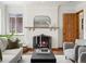 Cozy living room with a traditional fireplace, a decorative mirror, and comfortable seating creating a welcoming atmosphere at 2535 Leyden St, Denver, CO 80207