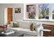 Bright living room featuring a comfortable couch, stylish decor, and a view of lush greenery through the large windows at 2535 Leyden St, Denver, CO 80207
