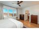 Bright main bedroom with wood floors, large windows, ceiling fan, and ensuite access at 11785 W Belleview Dr, Littleton, CO 80127