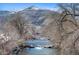 Scenic view of a flowing river surrounded by trees and a backdrop of mountains, highlighting the area's natural beauty at 1304 5Th St, Golden, CO 80403