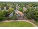 Aerial view of a home with a large deck, surrounded by mature trees and a green field at 9016 W Alabama Pl, Lakewood, CO 80232
