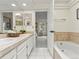Bathroom with double sinks, tile countertops, and a view into the adjacent bedroom at 9016 W Alabama Pl, Lakewood, CO 80232
