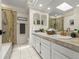 Bathroom featuring double sinks, tiled countertops, and a glass-enclosed shower at 9016 W Alabama Pl, Lakewood, CO 80232