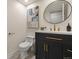 Modern half bathroom featuring a vessel sink, updated hardware and a stylish round mirror at 9016 W Alabama Pl, Lakewood, CO 80232
