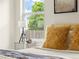Bedroom detail showcasing a fur throw pillow and side table with decor beside a bright window at 9016 W Alabama Pl, Lakewood, CO 80232