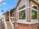 Inviting exterior featuring brick accents, a cozy porch, and an arrangement of windows, creating a warm curb appeal at 9016 W Alabama Pl, Lakewood, CO 80232