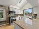 Well-lit kitchen featuring white cabinets, stainless steel appliances, a skylight and granite countertops at 9016 W Alabama Pl, Lakewood, CO 80232