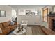 Cozy living room featuring hardwood floors, a fireplace, and seamless views to the kitchen at 9016 W Alabama Pl, Lakewood, CO 80232