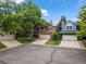 Street-level view of two homes with well-maintained yards and driveways, shaded by mature trees at 9016 W Alabama Pl, Lakewood, CO 80232