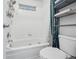 Standard bathroom with a white tiled bathtub, toilet, and metal storage shelves at 2003 S Helena St # D, Aurora, CO 80013