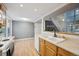 This eat-in kitchen has a sink with wood cabinetry and view to the living room and staircase at 2003 S Helena St # D, Aurora, CO 80013