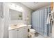 Well-lit bathroom featuring a vanity with a sink, toilet, and shower with blue accents at 1236 Sequerra St, Broomfield, CO 80020