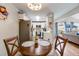 Cozy kitchen and dining area with stainless steel appliances, white cabinets, and wooden table with two chairs at 1236 Sequerra St, Broomfield, CO 80020