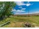 Expansive backyard featuring green grass and a long brick wall, offering privacy and plenty of space at 7684 Beverly Blvd, Castle Pines, CO 80108