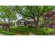 Charming single-story home features a lush front yard with mature trees and a classic wood fence at 7684 Beverly Blvd, Castle Pines, CO 80108