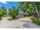 Driveway with a garage and a charming yard, shaded by mature trees and lush greenery at 7684 Beverly Blvd, Castle Pines, CO 80108