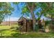 Quaint log cabin style outbuilding in a grassy backyard setting at 7684 Beverly Blvd, Castle Pines, CO 80108