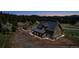 Aerial shot of a house with a detached garage, surrounded by a forest and mountains, offers privacy at 8191 S Homesteader Dr, Morrison, CO 80465