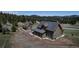Aerial view of a home with a long driveway, two buildings, and picturesque mountain views in the background at 8191 S Homesteader Dr, Morrison, CO 80465
