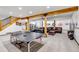Basement space featuring wooden support beams, lounge area, ping pong table, and stair access at 8191 S Homesteader Dr, Morrison, CO 80465
