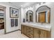 Bathroom featuring double vanity with a marble countertop, framed mirrors, and neutral tiling at 8191 S Homesteader Dr, Morrison, CO 80465