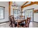 Rustic dining room with wood beams, light fixture, table and chairs at 8191 S Homesteader Dr, Morrison, CO 80465