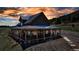 Charming two-story home with a wrap-around porch, set against a stunning sunset sky, offers picturesque outdoor living at 8191 S Homesteader Dr, Morrison, CO 80465