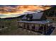 Charming two-story home with a covered porch and a beautiful sunset view overlooking green hills at 8191 S Homesteader Dr, Morrison, CO 80465