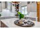 Bright kitchen featuring subway tile backsplash, white cabinets, and a large island with countertop decor at 8191 S Homesteader Dr, Morrison, CO 80465