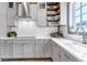 Well-lit kitchen featuring white subway tile, grey cabinets, and quartz countertops offers a clean and modern space at 8191 S Homesteader Dr, Morrison, CO 80465