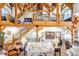 Open living area showcasing wood beam architecture, comfortable seating, and a staircase leading to a second level at 8191 S Homesteader Dr, Morrison, CO 80465