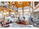 Spacious living room featuring natural wood beams, vaulted ceilings, fireplace, and comfortable furnishings at 8191 S Homesteader Dr, Morrison, CO 80465