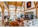 Bright living room featuring natural wood beams, vaulted ceilings, fireplace, and comfortable furnishings at 8191 S Homesteader Dr, Morrison, CO 80465